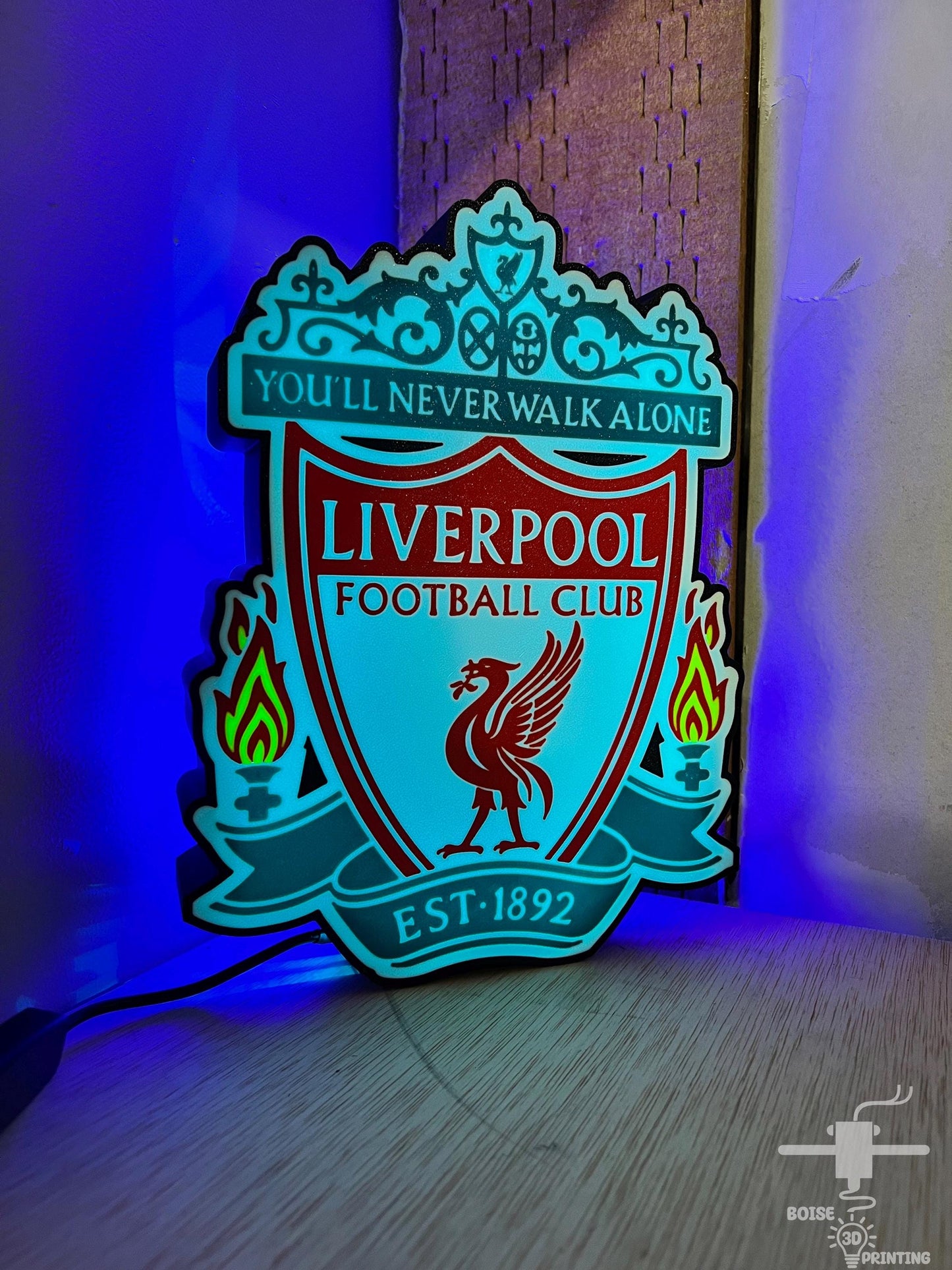 a liverpool football club illuminated sign on a wall