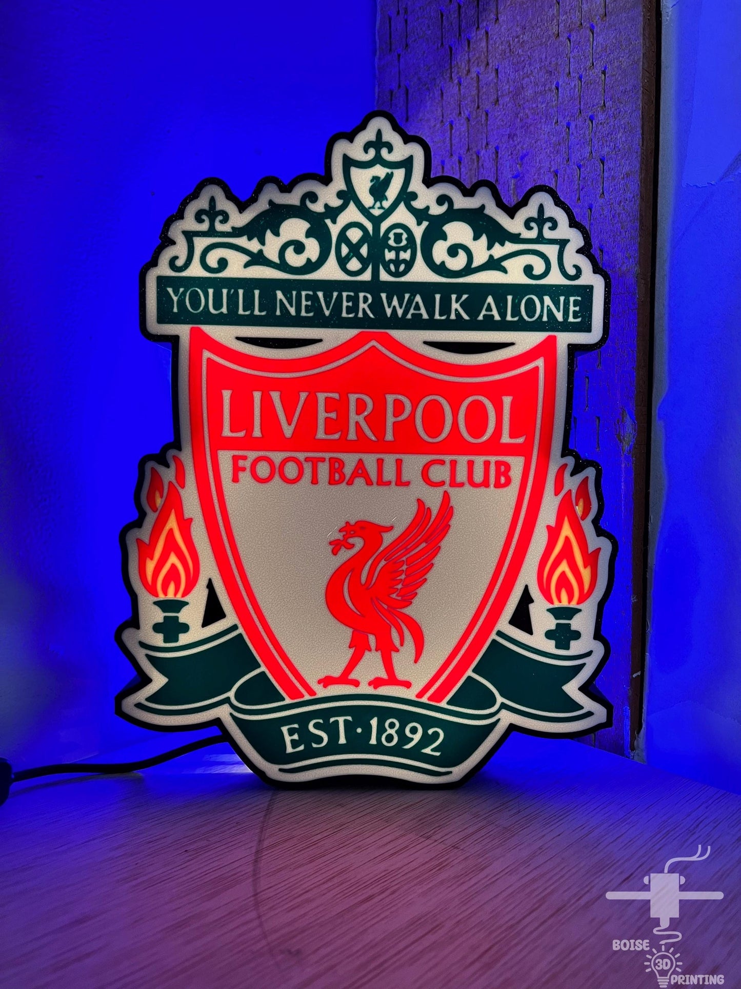 a liverpool football club neon sign on a wall