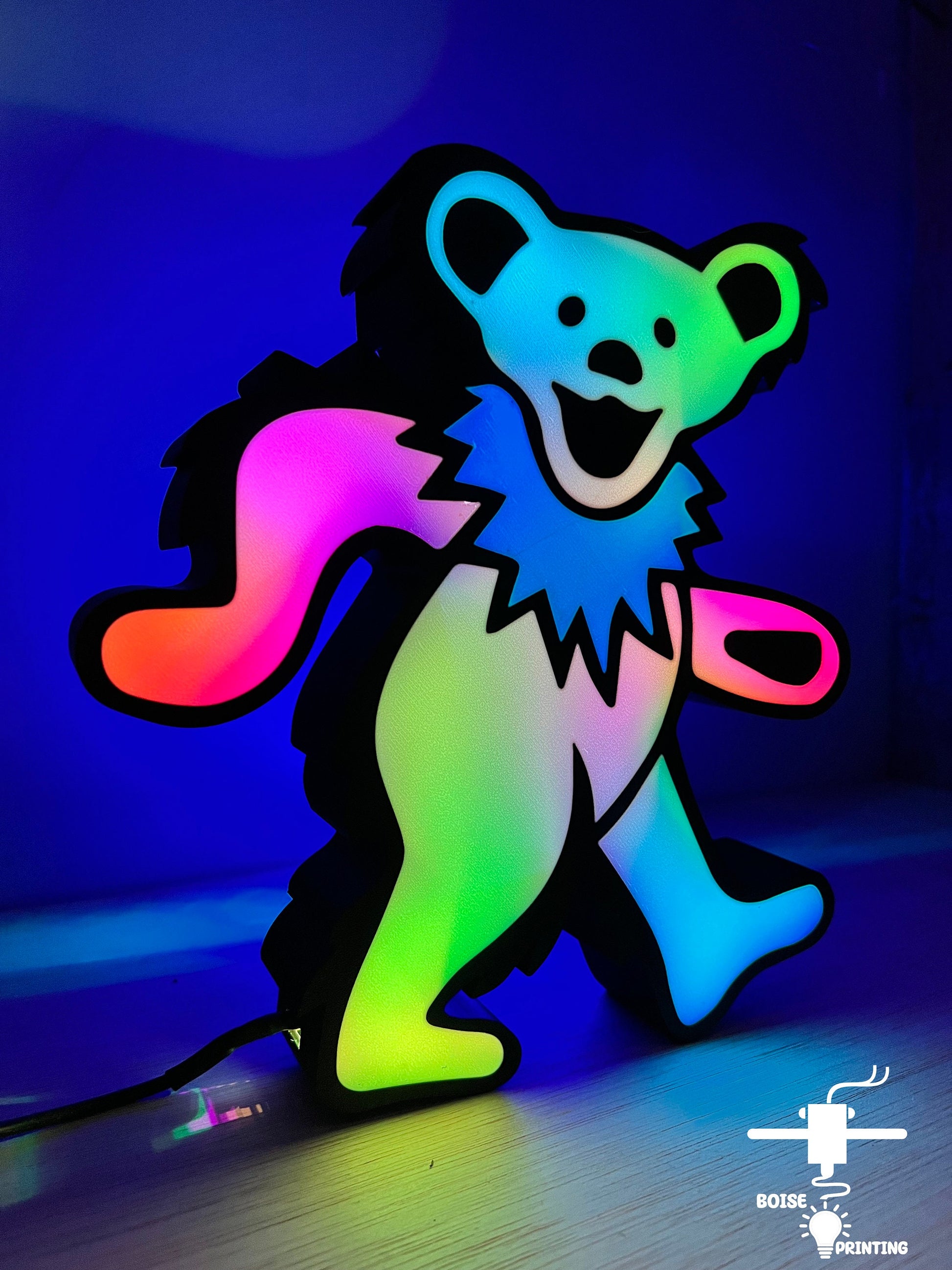 a lit up teddy bear on a wooden floor