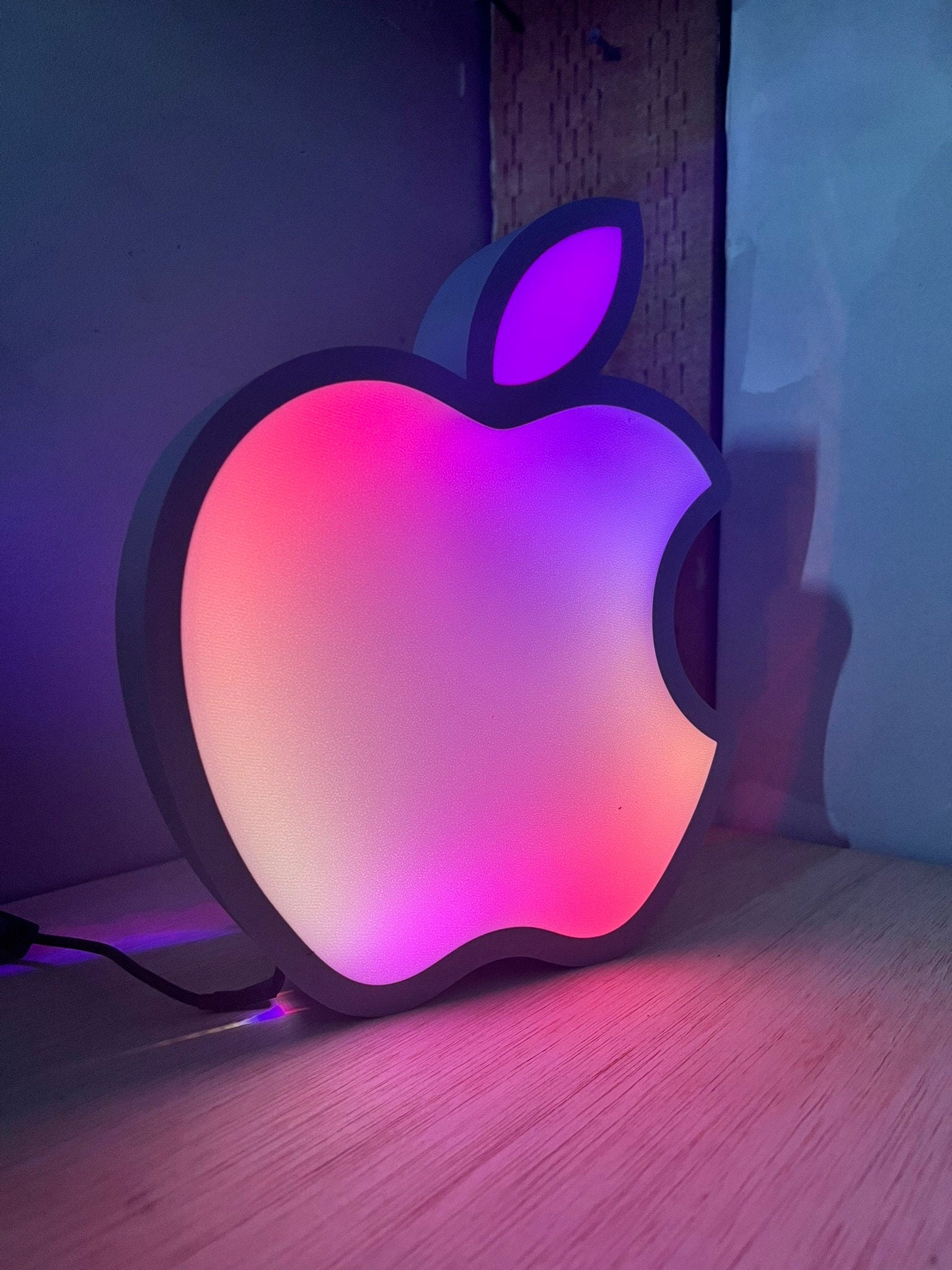 an apple logo is lit up on a table