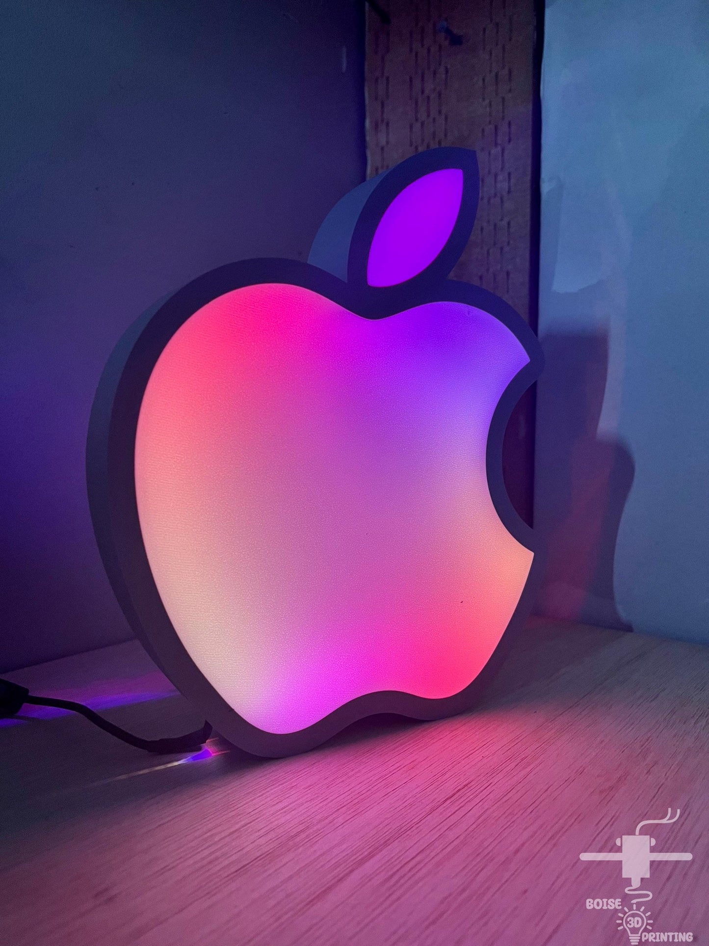an apple logo is lit up on a table