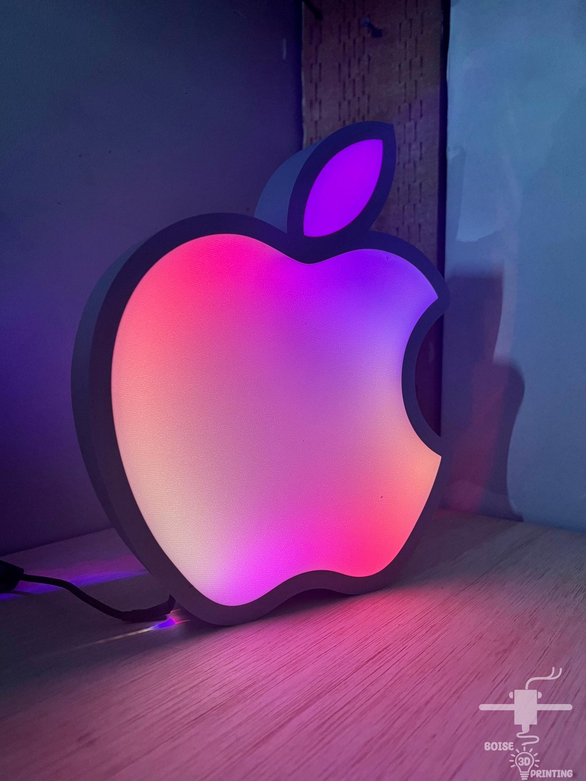 an apple logo is lit up on a table