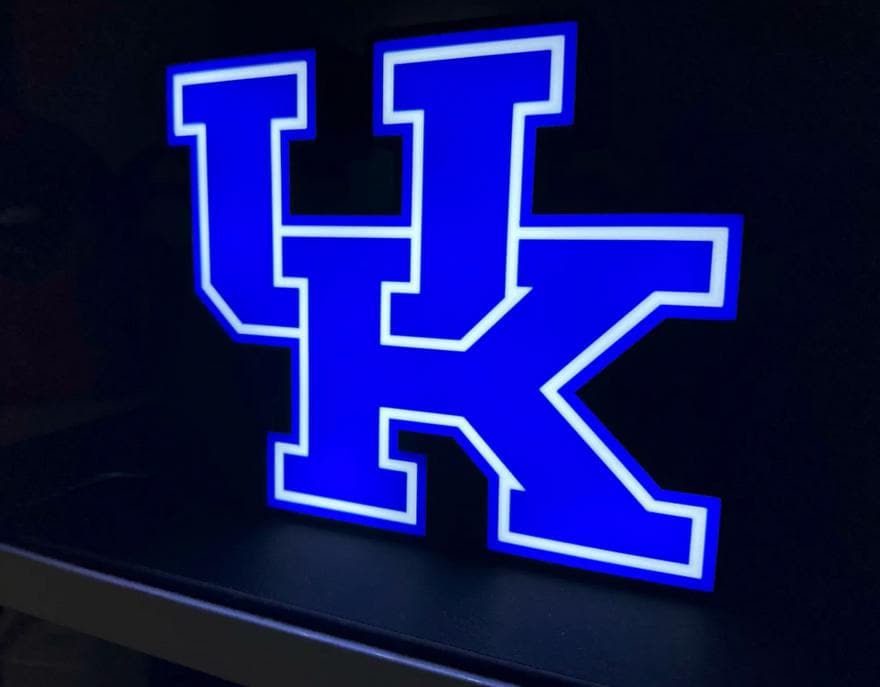 a lighted letter k on a black surface