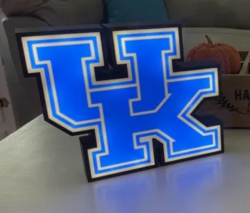 a lighted letter k on a table in a living room