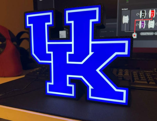 a blue lighted letter k sitting on top of a desk